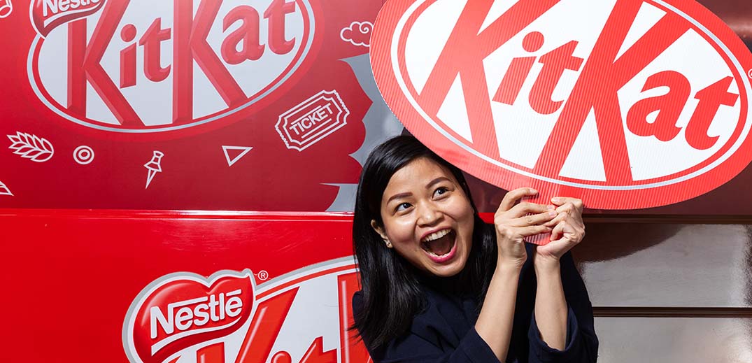 woman holds kit kat sign